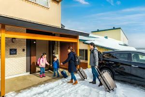 a family walking out of a house with their luggage at The Villa Seaside in Abashiri