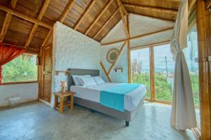 ein Schlafzimmer mit einem Bett in einem Zimmer mit Fenstern in der Unterkunft Cabalonga EcoAdventure in Puerto Cayo + 92 Fotos