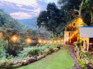 a garden with lights in front of a house at Downtown Lodge in Nuwara Eliya