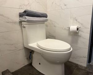 a bathroom with a white toilet with towels on it at Punta Lobos in Reynosa