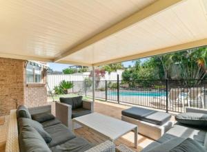 a patio with a couch and tables and a pool at Beach Street Stay in Harrington