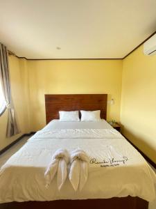 a bedroom with a bed with two towels on it at Tena Don Det Sunset Guest House in Don Det