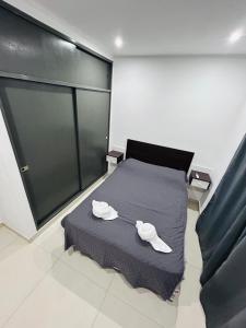 a bedroom with a bed with two white towels on it at Departamento ESTRADA ideal para pasajeros en tránsito, viajes laborales o estadías cortas Ubicado en Ezeiza, a solo 20 minutos del Aeropuerto Internacional Ministro Pistarini, ofrece comodidad y practicidad para hasta 4 personas in Tristán Suárez