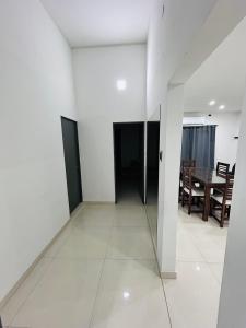a white hallway with a dining room and a table at Departamento ESTRADA ideal para pasajeros en tránsito, viajes laborales o estadías cortas Ubicado en Ezeiza, a solo 20 minutos del Aeropuerto Internacional Ministro Pistarini, ofrece comodidad y practicidad para hasta 4 personas in Tristán Suárez