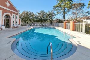 a swimming pool with blue water in a house at Emerald Escape in Destin, Miramar Beach! 4BR, 4BA, 1st Floor Bedroom, Sleeps up to 14, Golf Cart Included, Pool, Pet Friendly, Private Deeded Beach Access & Gated Community! in Destin