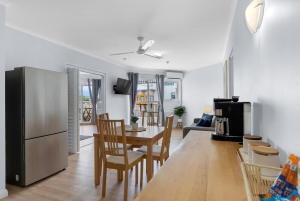 a kitchen and living room with a table and a refrigerator at Northshore Palms Apartment in Cairns North