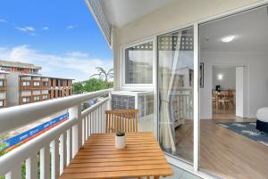 a balcony with a wooden bench on a balcony at Northshore Palms Apartment in Cairns North