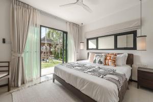 a bedroom with a large bed and a large window at Tranquil 4BR Garden Pool Oasis - Layan Beach in Laguna Phuket +43 photos