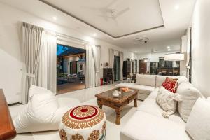 a living room with a white couch and a table at Tranquil 4BR Garden Pool Oasis - Layan Beach in Laguna Phuket