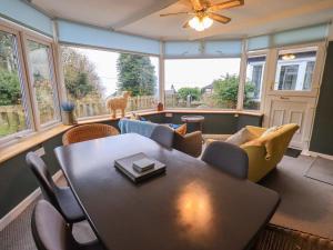 a living room with a table and chairs at Yewbarrow Cottage in Grange Over Sands