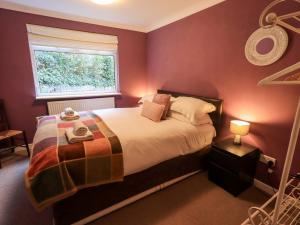 a bedroom with a bed and a window at Yewbarrow Cottage in Grange Over Sands