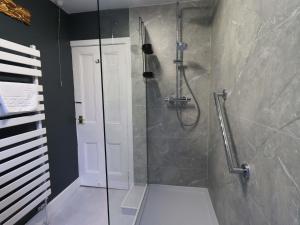 a bathroom with a shower with a glass door at Yewbarrow Cottage in Grange Over Sands +25 photos