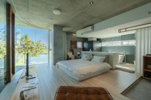 a bedroom with a white bed and a large window at Sugar House in Wujie