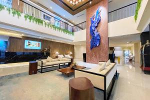 a lobby with couches and a blue sculpture on the wall at Elijah Hotel Dasmarinas City Cavite in Dasmariñas