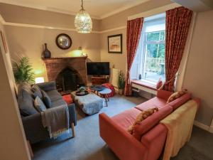 a living room with a couch and a fireplace at Yewbarrow Cottage in Grange Over Sands