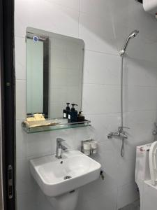 a white bathroom with a sink and a mirror at Moutain View in Yên Minh