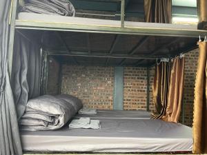 a bunk bed in a brick walled room at Moutain View in Yên Minh