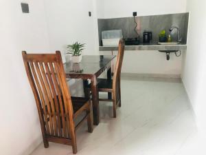 a dining room table with two chairs and a desk at Vihen Homestay in Dickwella +17 photos