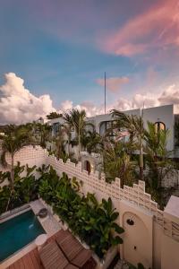 a resort with a swimming pool and palm trees at Solaya Villas Canggu in Canggu