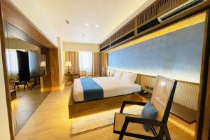 a bedroom with a bed and a chair in a room at Elijah Hotel Dasmarinas City Cavite in Dasmariñas +37 photos