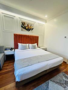 a bedroom with a large white bed and a couch at Hotel Airport Centre Point in Nagpur