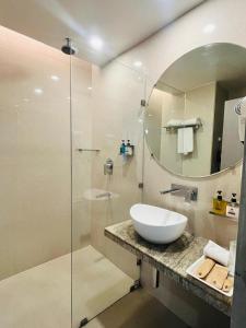 a bathroom with a sink and a mirror at Hotel Airport Centre Point in Nagpur