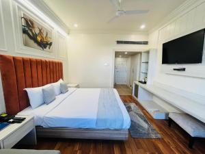 a bedroom with a large bed and a flat screen tv at Hotel Airport Centre Point in Nagpur