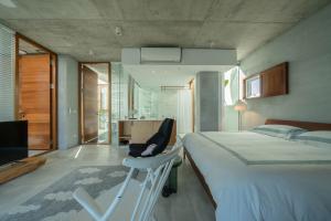 a bedroom with a bed and a chair and a television at Sugar House in Wujie
