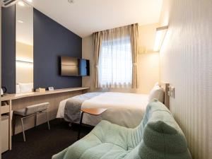 a hotel room with two beds and a chair at KOKO HOTEL Hakata Shinkansenguchi in Fukuoka +50 photos