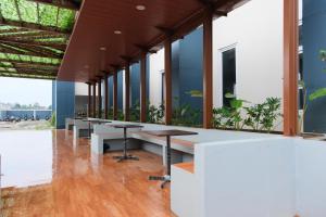 a row of tables in a building with windows at Grand Elhajj Banten in Tjipondoh Tiga