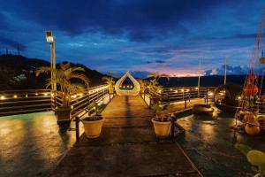 a dock with potted plants and lights at night at Serenity Busay Room 1 in Cebu City