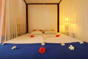 a large bed with flowers on it in a bedroom at Hotel Susantha Garden in Hikkaduwa +12 photos