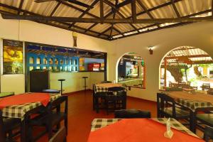 a restaurant with tables and chairs in a room at Hotel Susantha Garden in Hikkaduwa