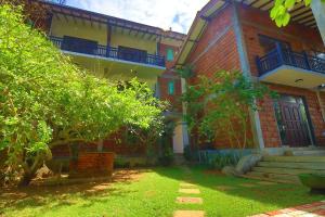 a large brick building with a yard in front of it at Hotel Susantha Garden in Hikkaduwa