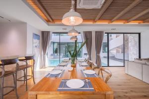 a dining room with a long table and chairs at Mövenpick Pool Villa6BR-NEW2025- in Na Jomtien