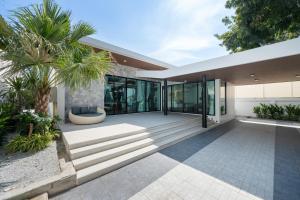 a modern house with glass doors and a porch at Mövenpick Pool Villa6BR-NEW2025- in Na Jomtien