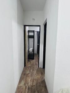 a hallway with white walls and a wooden floor at Departamento ESTRADA ideal para pasajeros en tránsito, viajes laborales o estadías cortas Ubicado en Ezeiza, a solo 20 minutos del Aeropuerto Internacional Ministro Pistarini, ofrece comodidad y practicidad para hasta 4 personas in Tristán Suárez