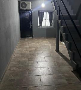 a hallway with a black door and a tile floor at Departamento ESTRADA ideal para pasajeros en tránsito, viajes laborales o estadías cortas Ubicado en Ezeiza, a solo 20 minutos del Aeropuerto Internacional Ministro Pistarini, ofrece comodidad y practicidad para hasta 4 personas in Tristán Suárez