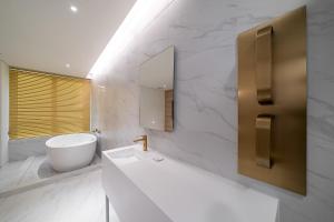 a white bathroom with a sink and a mirror at 루엠호텔안산 in Ansan