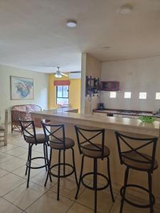 a kitchen with four bar stools and a counter at Amplio depto en el corazón comercial de Boca in Veracruz +14 photos