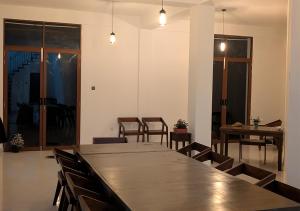 a large wooden table in a room with chairs at Ophelia in Diyatalawa