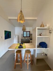 a kitchen with a table and stools in a room at Casas Gica in Pipa