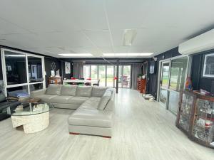 a living room with a couch and a table at Sunsets on Harbour Kauri or Totara Cabin in Matarangi