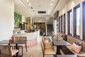 a restaurant with tables and chairs and a counter at Sans Stay Eskole Lampung in Geruntang