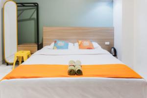 a bed with two pairs of shoes sitting on it at Sans Stay Eskole Lampung in Geruntang