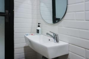 a bathroom sink with a mirror and a bottle of soap at Sans Stay Eskole Lampung in Geruntang +23 photos