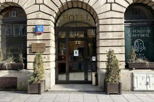a hotel entrance with two potted plants in front of it at Hotel Mazowiecki WOW in Warsaw