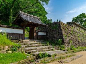 a stone wall with stairs in front of a building at スマートハウスみづほ in Hitoyoshi