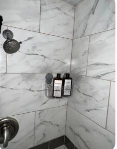 a bathroom with white marble walls and two bottles of soap at MidwestBNB Room1, quite cabin in the wood vibes in Minneapolis +34 photos