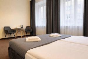 a bedroom with a bed with two towels on it at Hotel Mazowiecki WOW in Warsaw